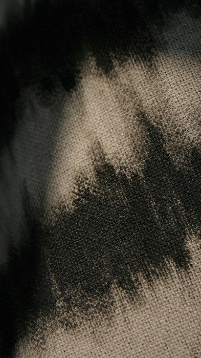 Macro photo of textured grey linen with painted black stripes.
